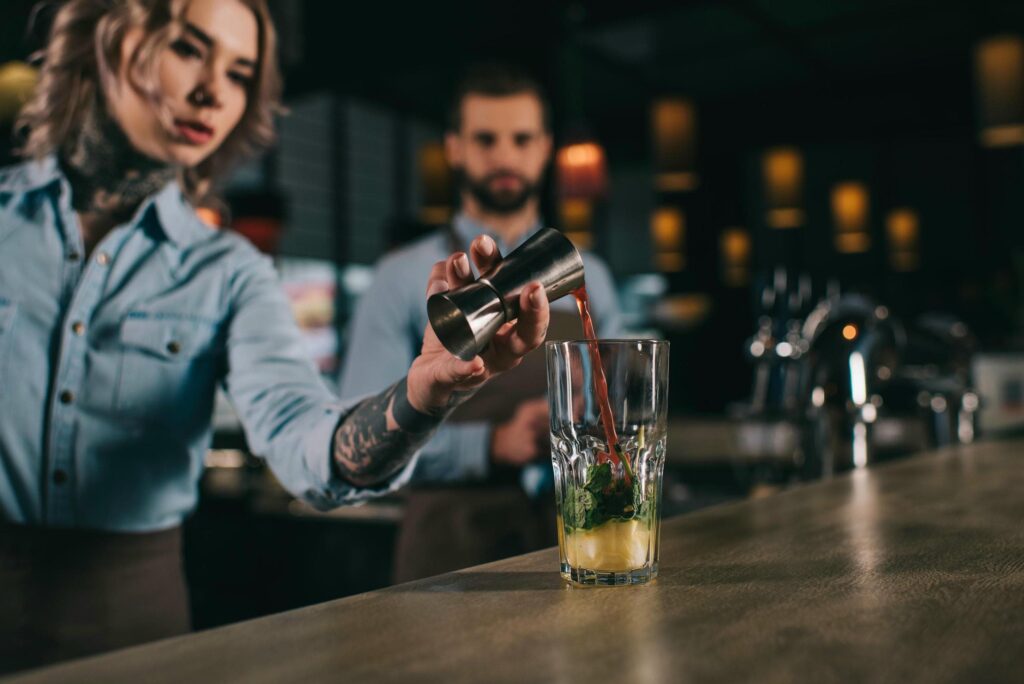 Bartender tillsätter ingrediens i drink bartenderutbildning Stockholm