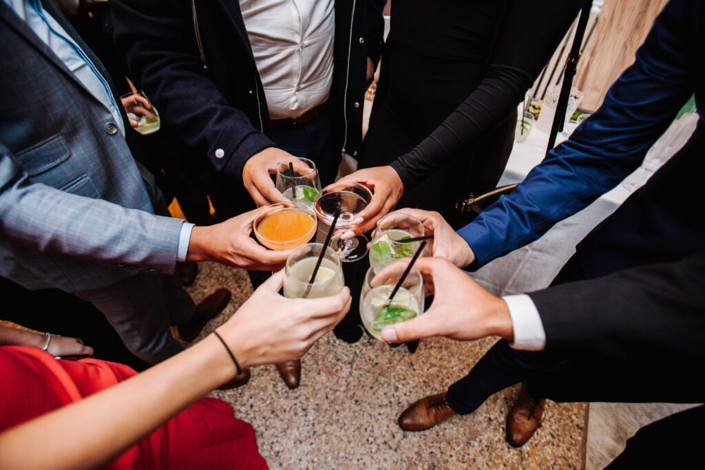 Vänner och familj som dricker och firar tillsammans på bröllop och möhippa