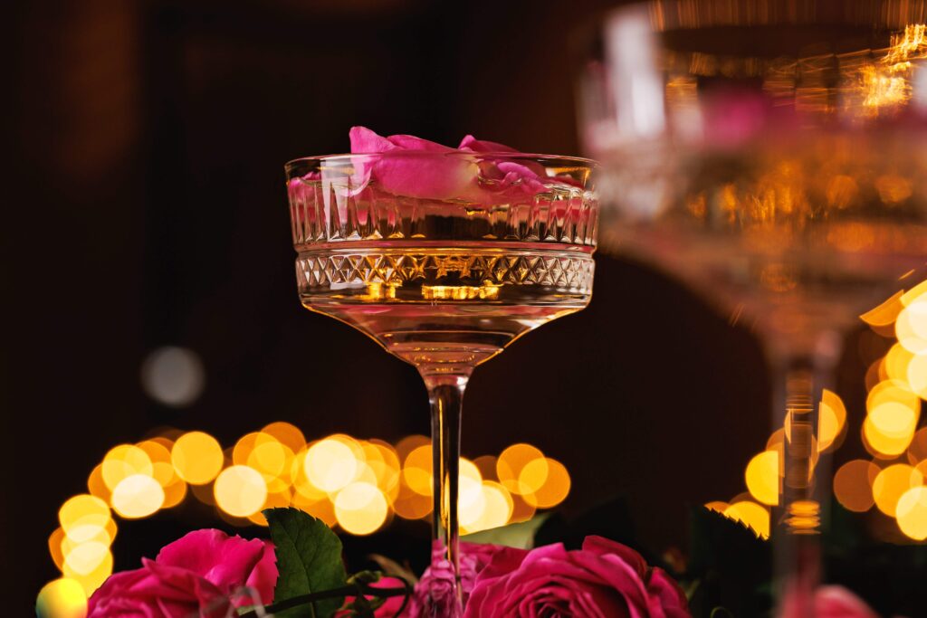 Lyxigt champagneglas med flytande rosenblad på romantiskt bröllop och möhippa