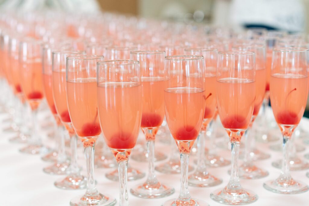 Rad av champagneglas med röda maraschinokörbär på elegant bröllop och möhippa