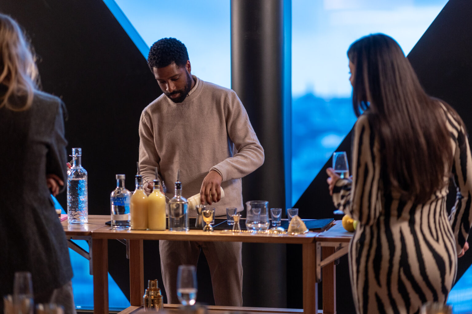 Bartendern blandar drinkar vid ett bord vid fönstret