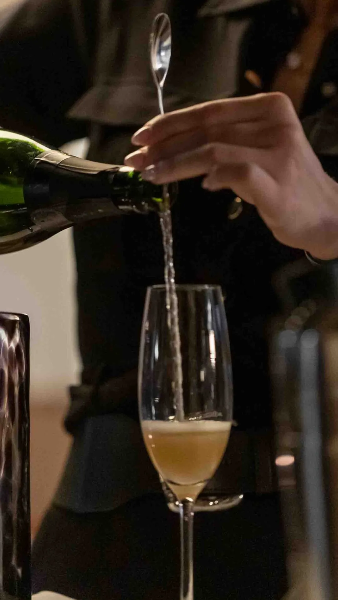 Deltagare häller upp bubbel i ett glas