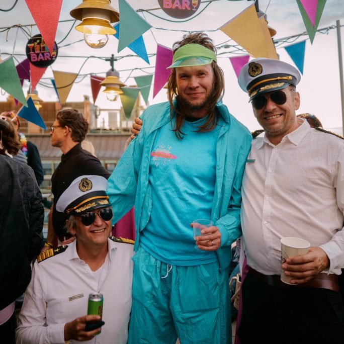 Glada deltagare i tropisk stil under en tiki-bar temafest på företagsevent.